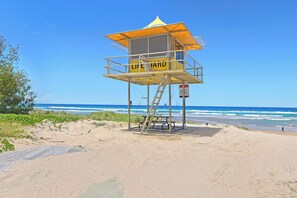 A lifeguard tower on a beach with clear skies and ocean waves. - Sierra Grand - Level 13 - CityScape (Broadbeach)