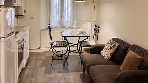 Eine Küche mit Essbereich, ein braunes Sofa und ein Tisch mit Stühlen.