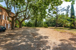 A gravel driveway leading to a building with a large tree in the foreground. - Holiday Home 'Grand Mas Provencal - 9 Ch - 18 Per' with Mountain View, Private Pool and Wi-Fi (La Farlède)