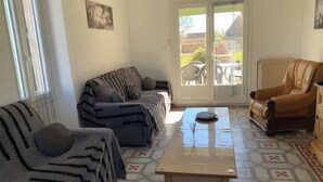 Un saló amb sofà, butaca i taula de centre.