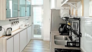 Une cuisine moderne dotée d’un îlot central, d’une plante suspendue et d’étagères intégrées.