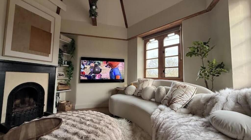 Una sala de estar acogedora con chimenea, televisor y un sofá cómodo.