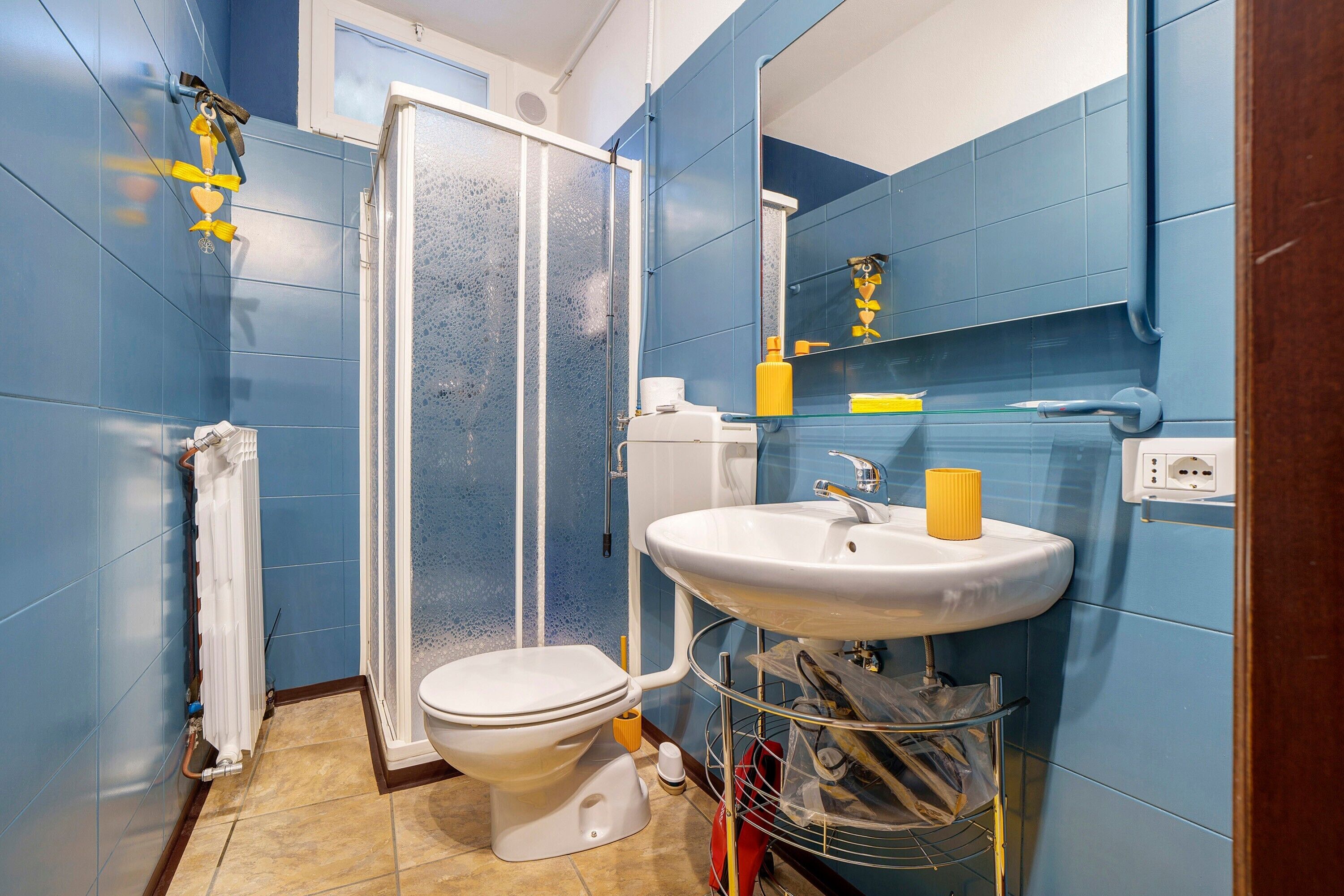 Ein Badezimmer mit Dusche, Toilette, Waschbecken und Spiegel.