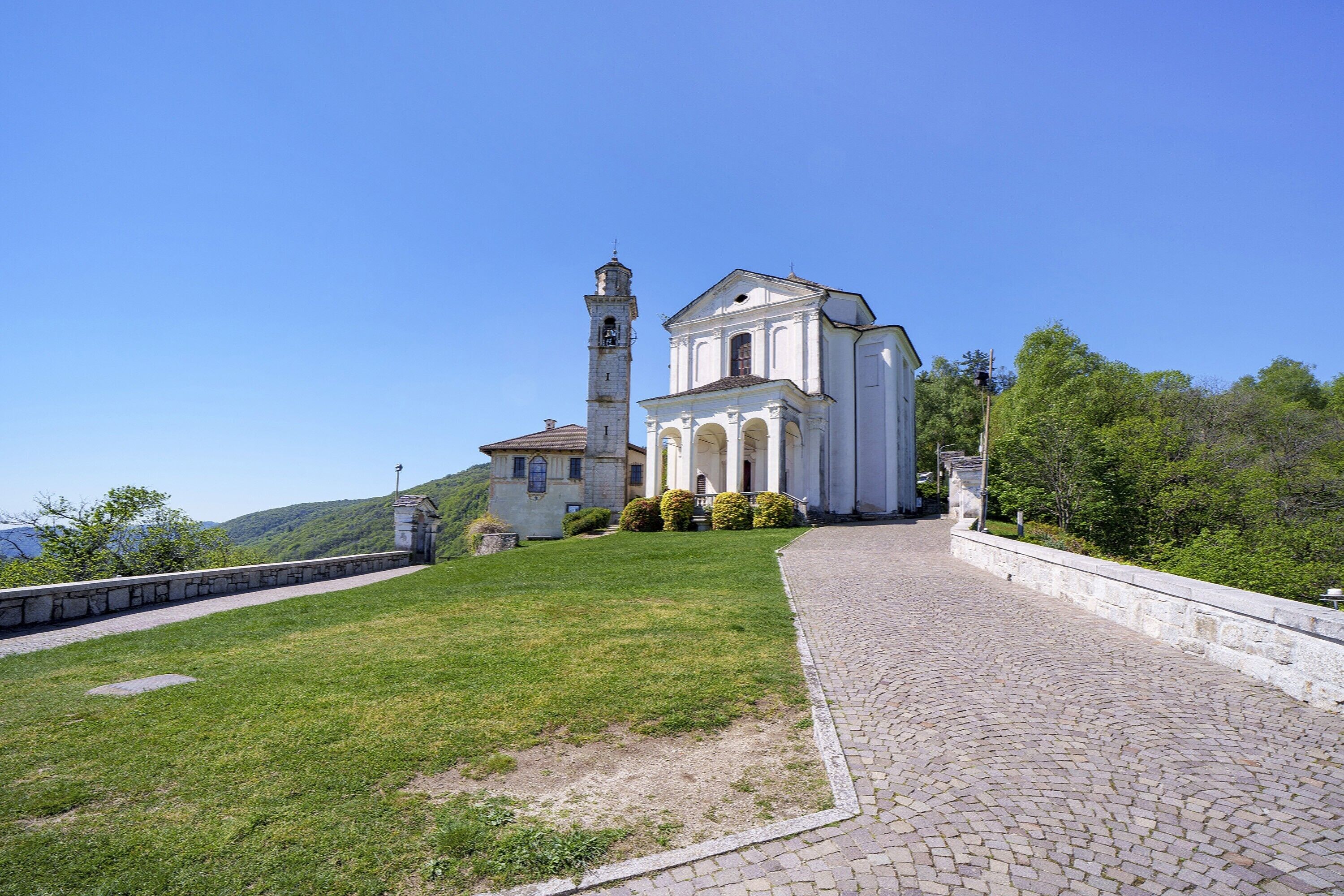 Une église dotée d’un clocher, d’un chemin pavé et d’une pelouse.