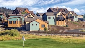Un campo da golf con l'asta di segnalazione in primo piano e case sullo sfondo.