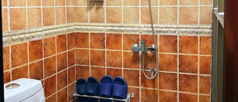 Ein Badezimmer mit Toilette, Dusche und Handtuchhalter.