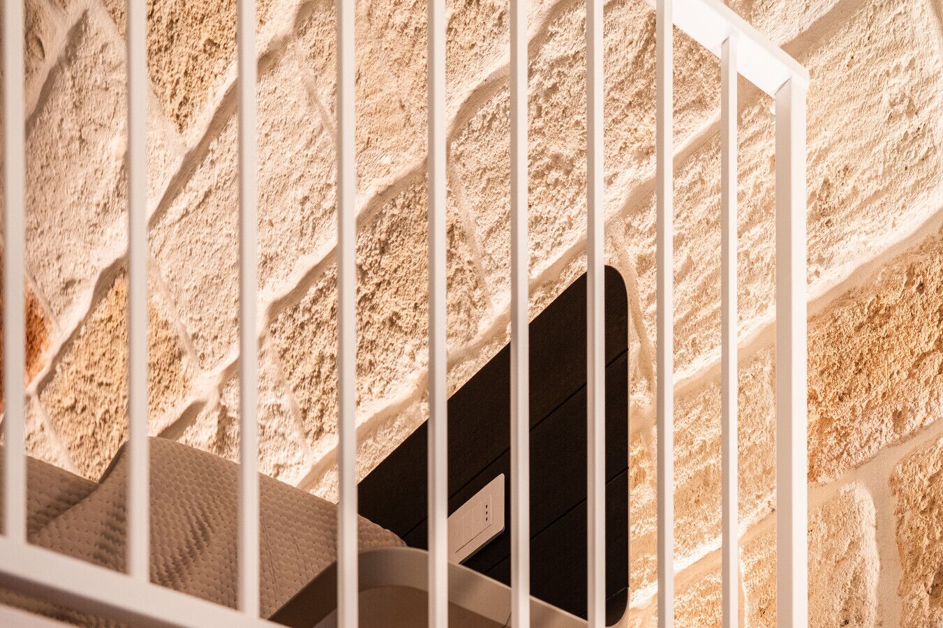 A staircase with a textured wall and a white railing.