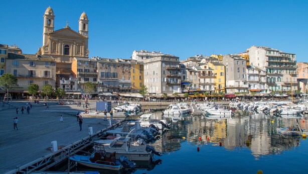 Una marina con barcos, una iglesia destacada y diversos edificios.