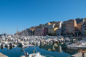 Un puerto deportivo con barcos amarrados, rodeado de edificios de varios pisos con balcones.