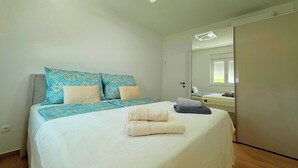 A bedroom with a bed, a bedside table, a mirror, and a wardrobe. - Apartment Top 5 with sunny balcony and sea view (Novalja)
