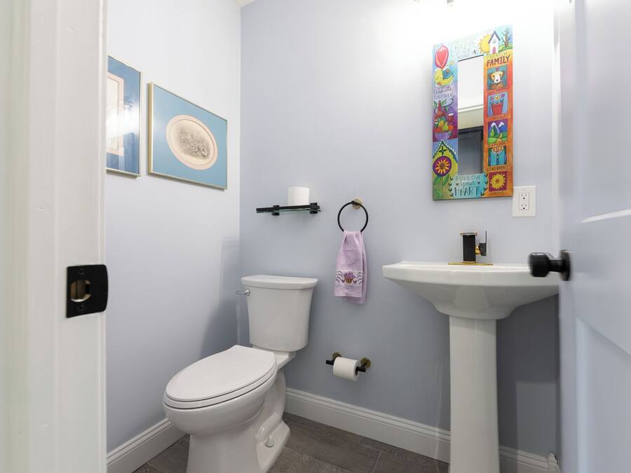 A bathroom with a toilet, sink, and towel rack.