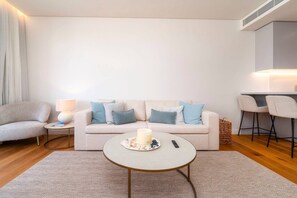 Ein modernes Wohnzimmer mit einer Couch, einem runden Couchtisch und einer Lampe.