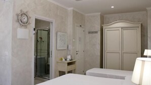 A hotel room with a bed, a desk with a lamp, a wardrobe, and a shower area. - MEDUSA Residence B&B  (Margherita di Savoia)