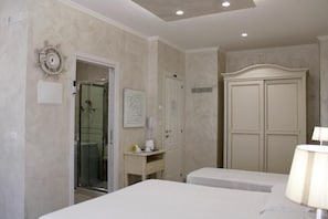 A hotel room with a bed, a desk with a lamp, a wardrobe, and a shower area. - MEDUSA Residence B&B  (Margherita di Savoia)
