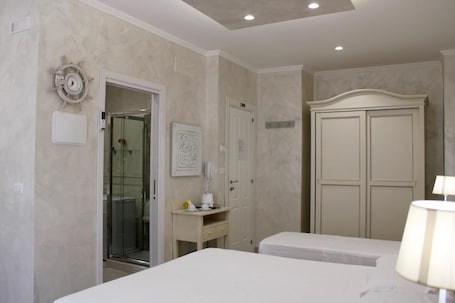 Camera d'albergo con un letto, una scrivania con una lampada, un armadio e un angolo doccia.. MEDUSA Residence B&B