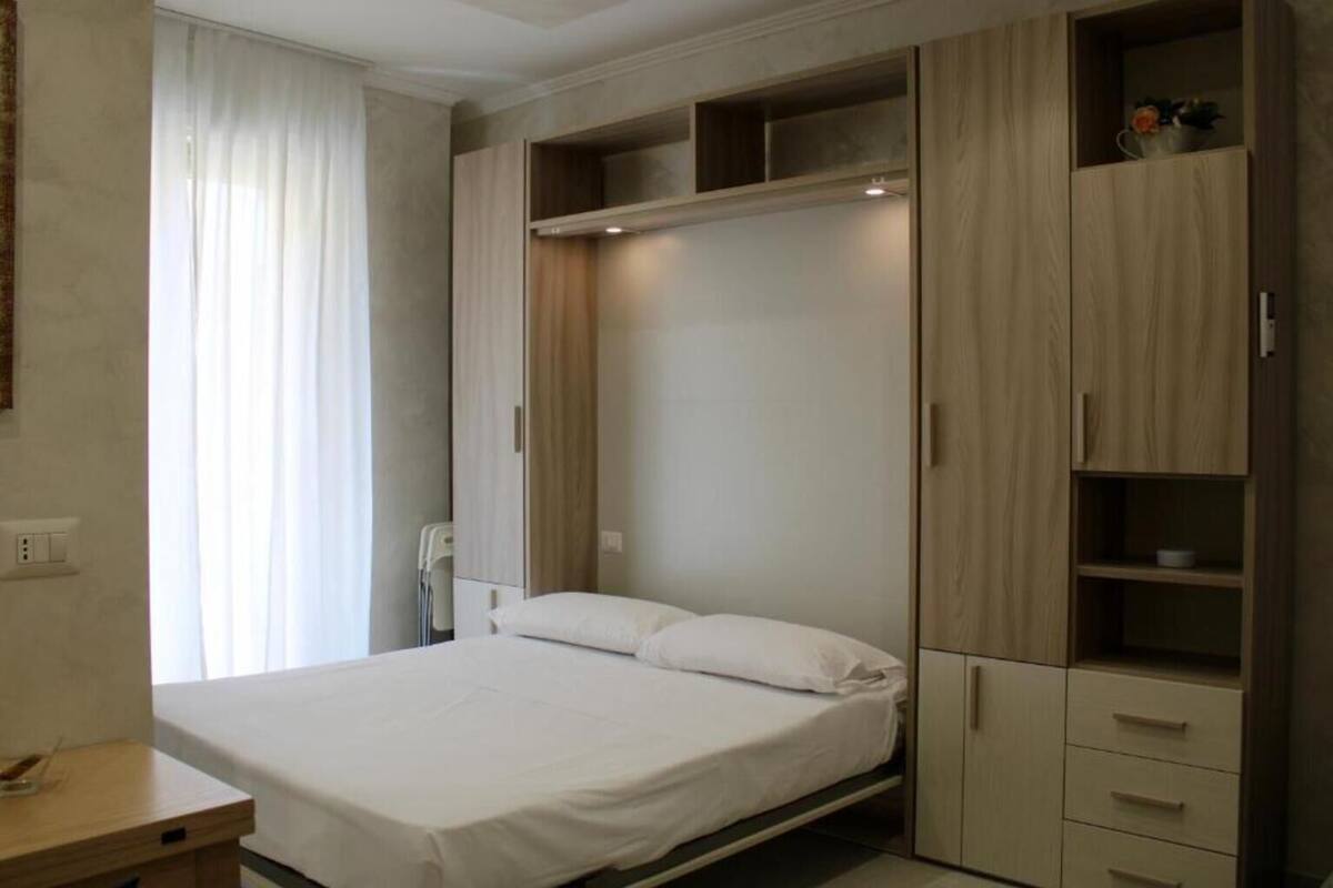 Ein Schlafzimmer mit einem Bett, einem Schreibtisch und eingebauten Schränken.