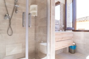 A modern bathroom with a glass shower enclosure, a wooden vanity, and a large window. - Casa Ombrina - Three Bedroom House, Sleeps 8 (Orosei)