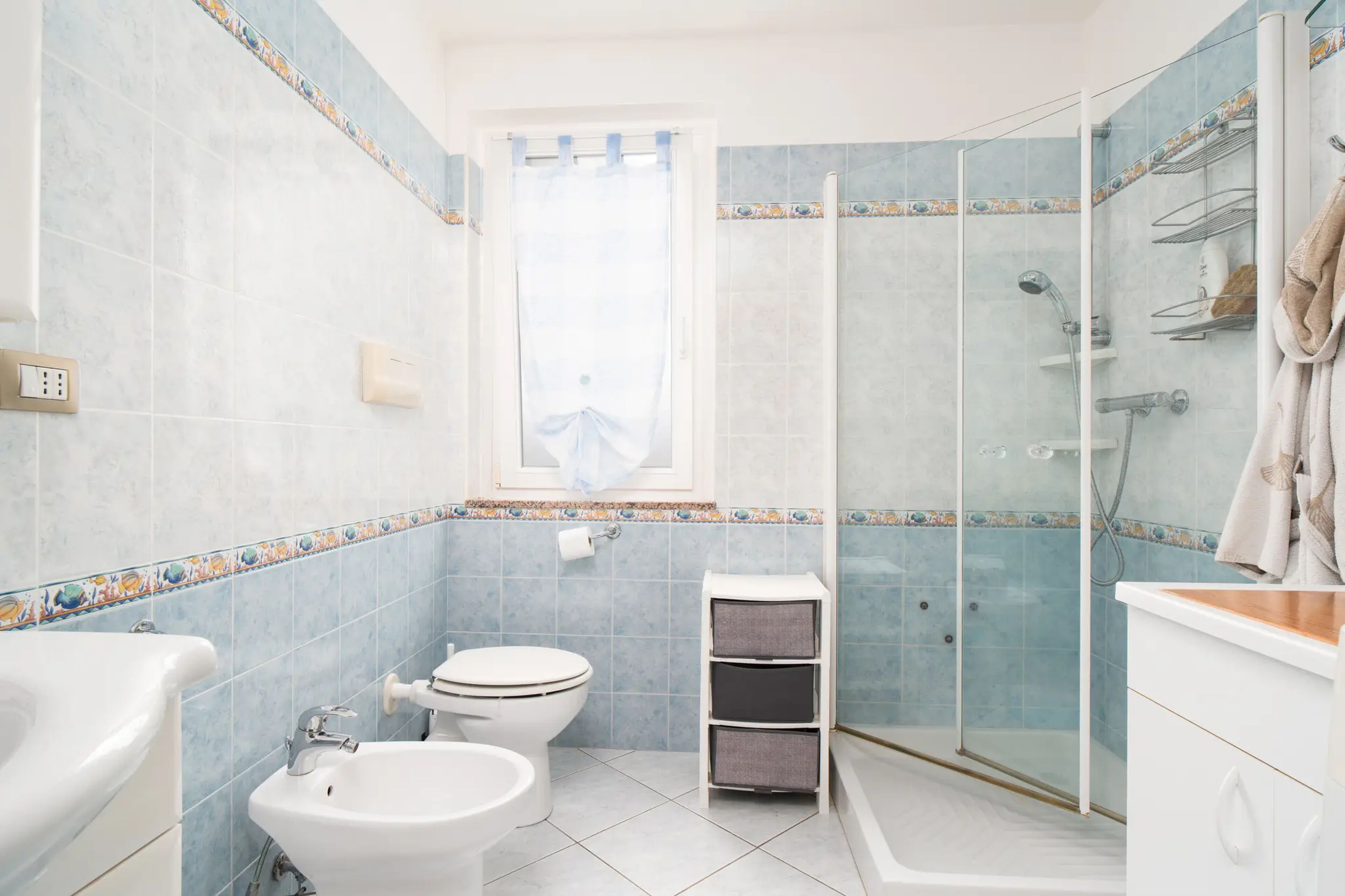 Un baño con ducha, inodoro, bidé y lavabo.