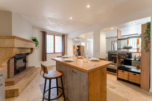 A modern kitchen with a central island, a built-in oven, and a bar stool. - “Domaine De Meyrol - Gîte 4” Apartment with Mountain View, Wi-Fi, and Air Conditioning (Eyguières)