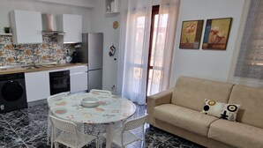 Un espace de vie compact comprenant une cuisine, un coin repas et un canapé.