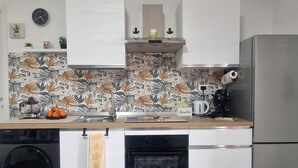 Une cuisine équipée d’un lave-linge, d’un four et d’un réfrigérateur.