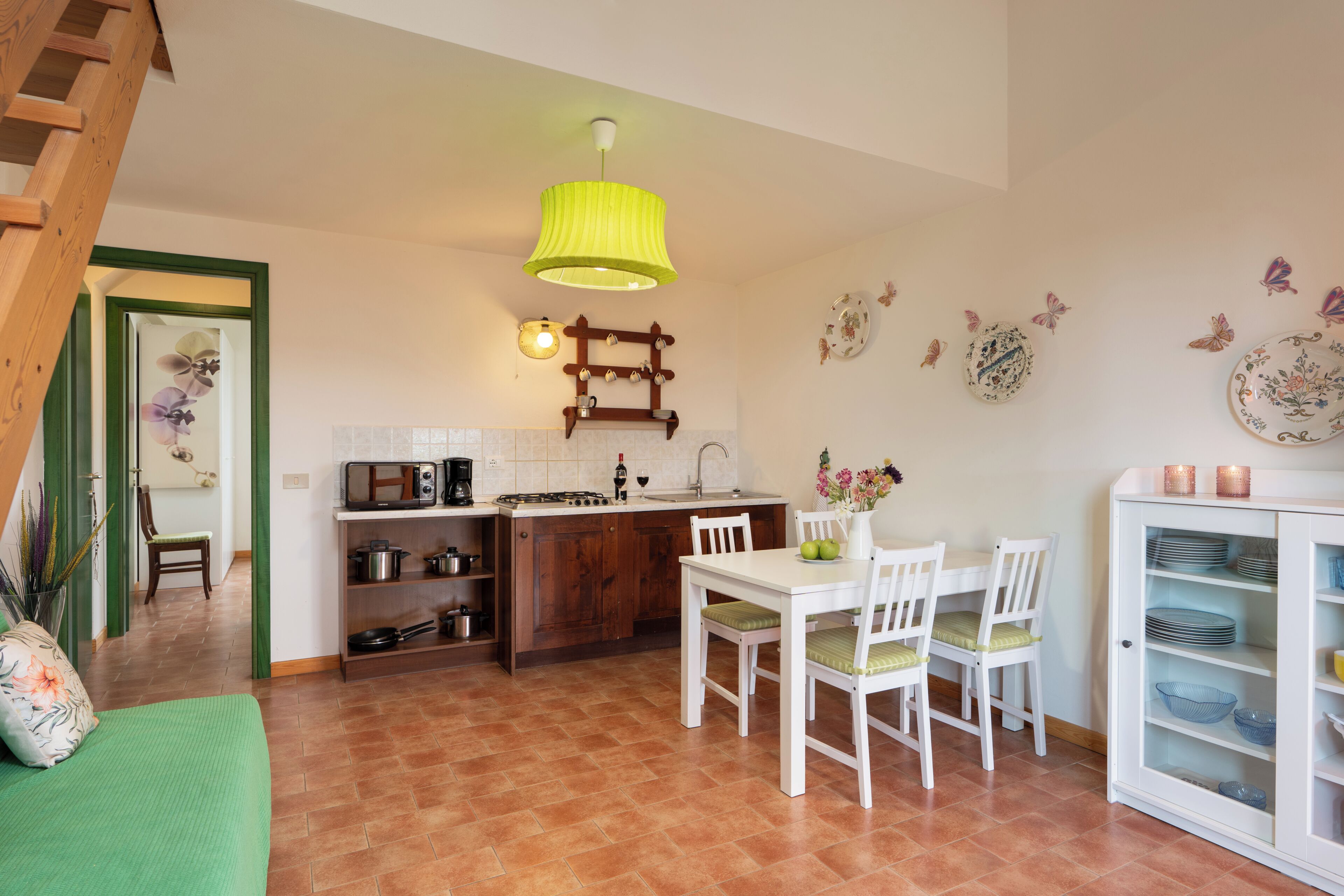 Een keuken met een eettafel, stoelen, een kast en een hanglamp.