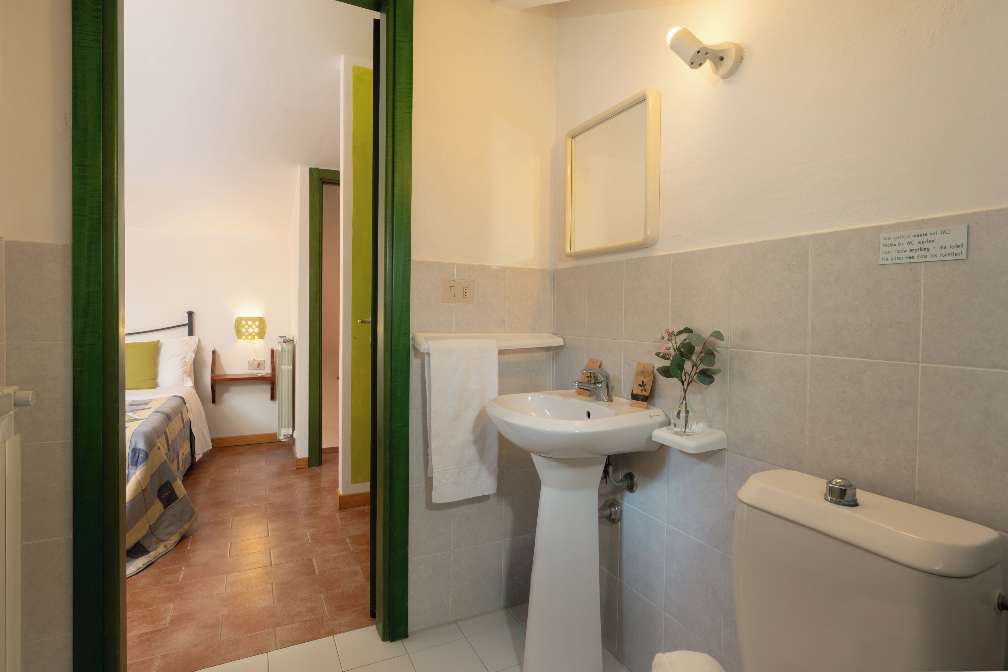A bathroom with a sink, toilet, and mirror.