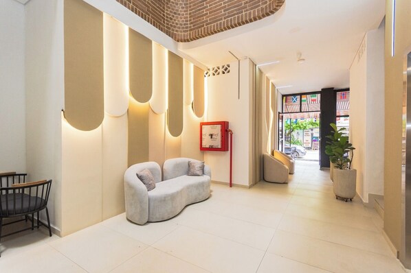 A modern interior with a sofa, a dining area, and a view to the outside.