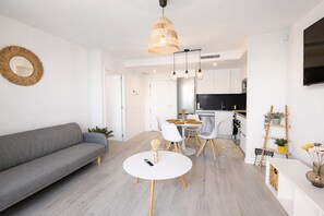 A modern living room with a sofa, a round dining table, and a kitchen in the background. - Ap1142 in Denia With 1 Bedrooms and 1 Bathrooms (Denia)