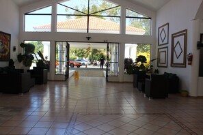 A spacious lobby with high ceilings, large windows, and a tiled floor. - Cozy 1-bedroom apartment with AC in soothing Sosúa (Sosúa)