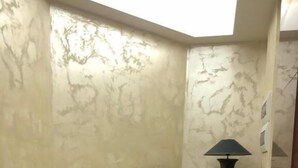 A corner room with a brown leather sofa, a small round table with a lamp, and a marble-patterned wall. - Hotel President Scornicesti (Scornicesti)