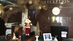 A reception desk with a 'RECEPTION' sign, a decorative tree, a Santa Claus figurine, and a small Christmas tree. - Hotel President Scornicesti (Scornicesti)