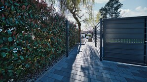 A paved pathway flanked by a hedge and a metal gate. - Meier Design Apartment - Exclusive vacation apartment in Friedrichsruhe (Zweiflingen)