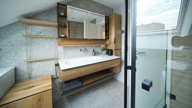 A modern bathroom with a large mirror, wooden vanity, and a glass shower enclosure. - Meier Design Apartment - Exclusive vacation apartment in Friedrichsruhe (Zweiflingen)