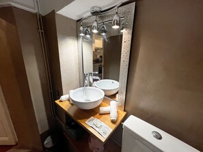 A bathroom with a double sink, a mirror with a textured frame, and a towel rack. - Cocon Barillerie 2 Old Town (Nice)