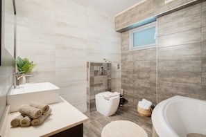 Ein modernes Badezimmer mit Waschbecken, Toilette und Badewanne.