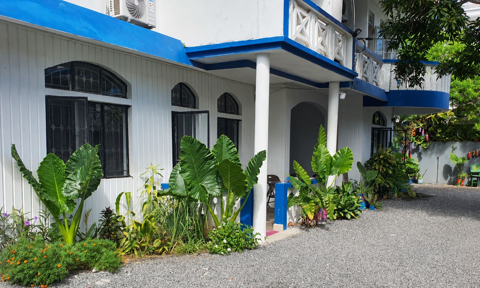 Un edificio con facciata blu e bianca, ampie finestre e un portico coperto.