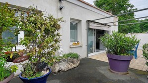 A building with a white exterior, a door, and a window. There are potted plants and a sign that says 'Bienvenue'. - Independent House 5 Minutes from the Beaches (Les Mathes)