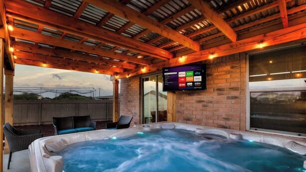 Ein Whirlpool mit Holzboden und einem Fernseher, der Sendersuchlauf anzeigt.
