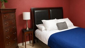 A bedroom with a bed, a nightstand, a lamp, a dresser, and a ceiling light fixture. - 5BR retreat/Sleeps large groups/Spacious backyard/Near South Padre and Space X. (Brownsville)