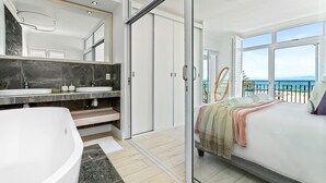 A modern bathroom with a freestanding bathtub, dual sinks, and a large mirror. - Sea La Vie (Cape Town)