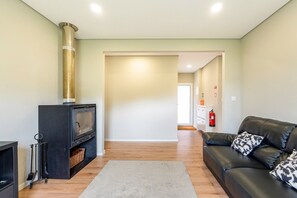 Ein Wohnzimmer mit Kamin, einer Couch und einem Flur, der in einen anderen Raum führt.