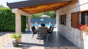 An outdoor patio with a pool, seating, and a pergola. - Vacation home Bozena with pool (Donji Vinjani)