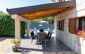 An outdoor patio with a pool, seating, and a pergola. - Vacation home Bozena with pool (Donji Vinjani)
