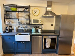Une cuisine équipée d’un four à micro-ondes, d’un four, d’un lave-vaisselle et d’un réfrigérateur Siemens.