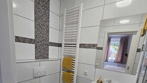 A modern bathroom with a toilet, sink, and towel rack. - Vacation apartment with several living units (up to 20 people) (Wunsiedel)