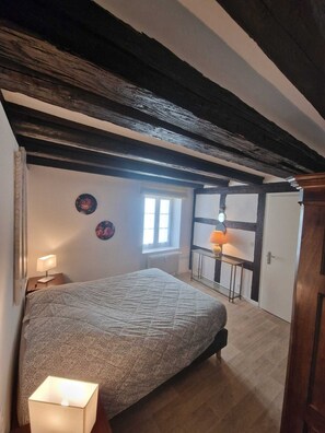 A bedroom with a bed, bedside lamps, a window, and a door. - LARGE 2-BEDROOM APARTMENT OVERLOOKING PETITE VENISE WITH BALCONY AND PRIVATE PARKING (Colmar)