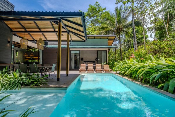 A modern outdoor pool area with a covered seating area and lush tropical vegetation. - Hidden House: Luxury, Private Pool, 4WD Only (Punta Uva)