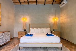 A bedroom with a large bed, two bedside tables, and two wall-mounted lamps. - Hidden House: Luxury, Private Pool, 4WD Only (Punta Uva)