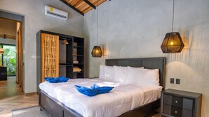 A modern bedroom with a large bed, bedside tables, and a wardrobe.